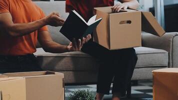 A couple of men and women talking while packing things into cardboard boxes video