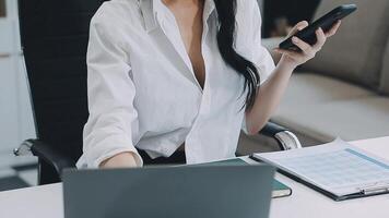 Asian businesswoman in formal suit in office happy and cheerful during using smartphone and working video