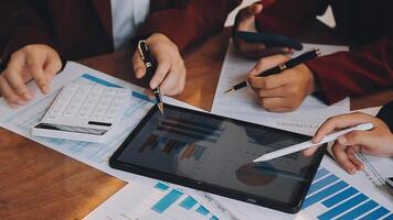 Financial analysts analyze business financial reports on a digital tablet planning investment project during a discussion at a meeting of corporate showing the results of their successful teamwork. video