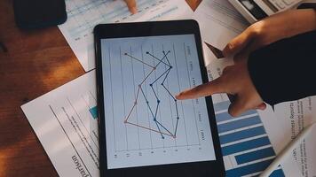 finanzanalysten analysieren während einer diskussion auf einem unternehmenstreffen geschäftsfinanzberichte zu einem investitionsprojekt zur planung digitaler tabletten und zeigen die ergebnisse ihrer erfolgreichen teamarbeit. video