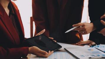 Financial analysts analyze business financial reports on a digital tablet planning investment project during a discussion at a meeting of corporate showing the results of their successful teamwork. video