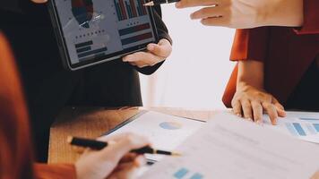 Financial analysts analyze business financial reports on a digital tablet planning investment project during a discussion at a meeting of corporate showing the results of their successful teamwork. video