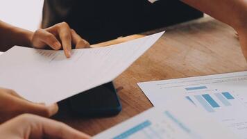 Financial analysts analyze business financial reports on a digital tablet planning investment project during a discussion at a meeting of corporate showing the results of their successful teamwork. video