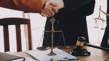 Lawyer shaking hands with a client making about documents, contracts, agreements, cooperation agreements with a female client at the lawyer's desk and a hammer at the table. video