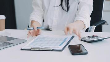 femme d'affaires asiatique en costume formel au bureau heureuse et joyeuse lors de l'utilisation d'un smartphone et du travail video