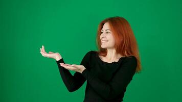 A red-haired girl shows some object in her hands, then shows class, raises her thumb up, waves her hand, smiles. video