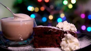Brownie Sahne pulverisiert Zucker Schokolade Kuchen Glas mit Cappuccino und Weiß Kuchen mit Sahne auf hölzern Tafel. Latté Macchiato auf braun Hintergrund video