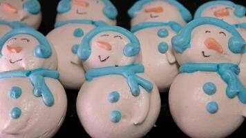 boneco de neve sobremesa macaron decorado com chapéu e cachecol com colorida luzes e bokeh piscando em primeiro plano e Natal árvore em fundo. alegre Natal e feliz Novo ano festivo conceito video