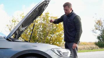 auto fallimento incidente ispezione olio livello. veicolo dai un'occhiata motore olio livello. auto motore surriscaldamento. triste deluso uomo su rotto auto incidente. Aperto cappuccio il motore video