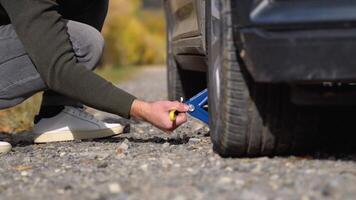 A young man with a gray car that broke down on the road. Changing tire on broken car on road video