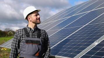 Masculin ingénieur dans uniforme en marchant par solaire panneau champ pour examen. écologique construction. solaire Puissance gare. vert énergie concept video