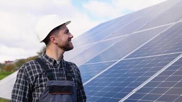 masculino ingeniero en uniforme caminando mediante solar panel campo para examen. ecológico construcción. solar poder estación. verde energía concepto video