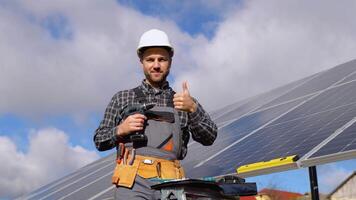 Portrait of confident engineer of solar cell farm industry. Close up portrait of male worker in protective helmet standing near solar panel video