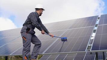 trabajador en uniforme limpieza solar paneles con cepillo y agua video