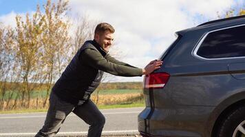 Man pushing a broken car down the road. Transportation, traveling concept video