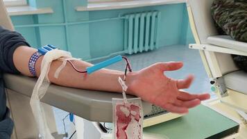 The hand of a man who donates blood. Male donor gives blood in a mobile blood donation center. Blood samples video