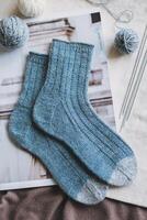 Hand knitted socks with needles and yarn balls. Concept for handmade and hygge slow life. photo