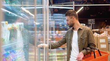 jong Mens boodschappen doen in zuivel sectie Bij supermarkt. een Mens aan het doen boodschappen doen Bij markt terwijl buying kwartel eieren video