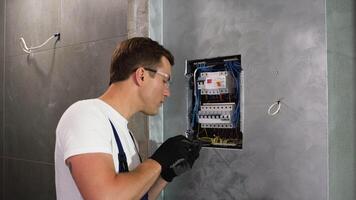 electricista reparando eléctrico caja y utilizando destornillador en corredor video