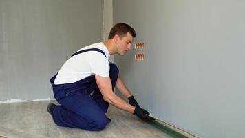 trabalhador instalando casa chão. carpinteiro deitado laminado pavimentação. instalando laminado chão video