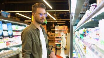 un confuso hombre no puedo escoger lechería productos en el supermercado video