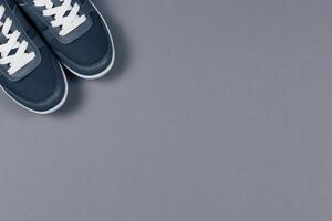 Grey sneakers on the grey background. Concept for healthy lifestyle and everyday training. photo