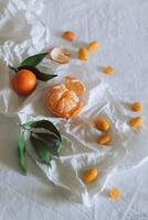 Fresh juicy citrus fruits with green leaves on white craft paper. Healthy food. photo