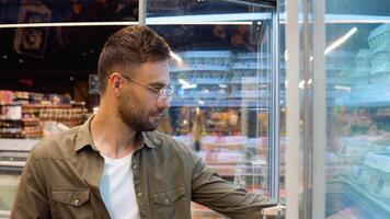 Young man shopping in dairy section at supermarket. A man doing shopping at market while buying quail eggs video