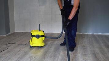 professionell rengöring efter renovering i de rum. en man dammsugare de golv. rengöring efter reparera eller renovering video