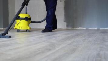 professioneel schoonmaak na vernieuwing in de kamer. een Mens stofzuigers de vloer. schoonmaak na reparatie of vernieuwing video