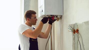 Professional engineer installing a natural gas boiler at home, he is checking the pipes video