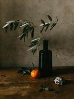 Still life with olive branch and tangerines. Dark rustic background. photo