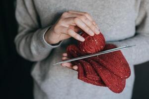 Female hands with hand knitted socks and yarn balls for knitting. photo