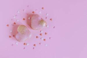 Tasty french macarons with heart decoration on a pink pastel background. photo