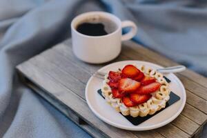 Cup of black coffee and a strawberry cake on a on a grey background. photo