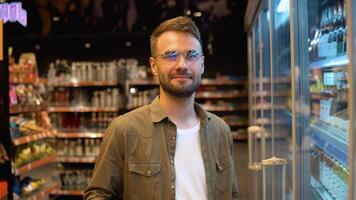 retrato do uma homem às supermercado. homem escolhendo a certo produtos dentro uma supermercado video