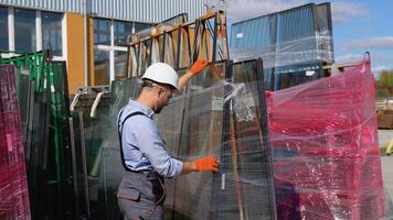 Professional man worker in a window warehouse prepares windows for sending video