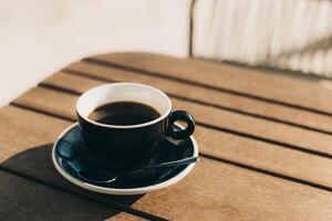 Cup of black coffee on a table in a street cafe. Selective focus. photo