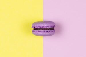 Purple french macaron on a yellow and purple background. photo