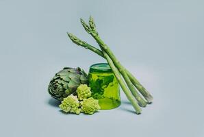 Fresh Artichoke, Asparagus and Romanesque cabbage on a grey background. photo