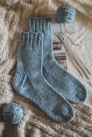 Hand knitted socks with needles and yarn balls. Concept for handmade and hygge slow life. photo