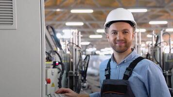 operatör av maskin. industriell arbetstagare bär säkerhet enhetlig och hjälm inomhus i fabrik video