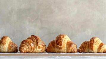 Assortments of fresh french croissants on a light wooden table in a bakery. photo