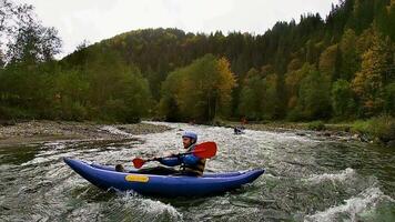 ein glücklich enthusiastisch männlich im Blau aufblasbar Kanu haben ein Spaß Reiten im Ruhe Wasser von ein Fluss video