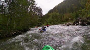 ein Kerl im ein Kajak Segel auf ein Berg Fluss. Wildwasser Kajak fahren, extrem Kajak fahren video