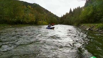 A happy entusiastic males in blue inflatables canoes having a fun ride in calm waters of a river video