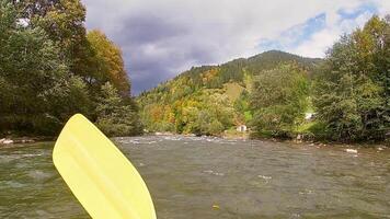 en kille i en kajak segel på en berg flod. vitvatten Kajakpaddling, extrem Kajakpaddling video