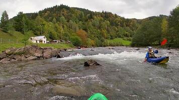 ein Kerl im ein Kajak Segel auf ein Berg Fluss. Wildwasser Kajak fahren, extrem Kajak fahren video