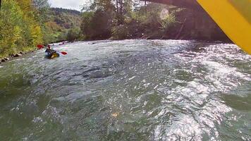 un chico en un kayac paño en un montaña río. agua Blanca kayak, extremo kayak video