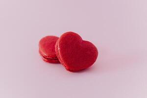 rosado corazón conformado francés macarons en un rosado pastel antecedentes. concepto para San Valentín día. foto